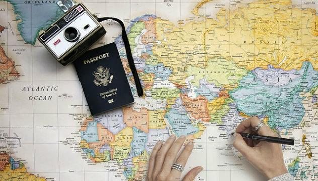 person planning a travel tour with a map and passport