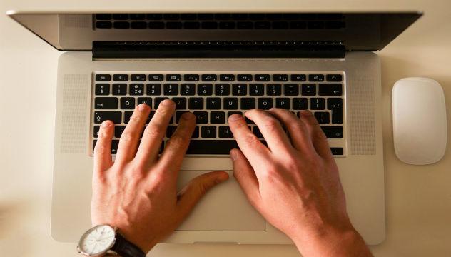 person typing on a macbook