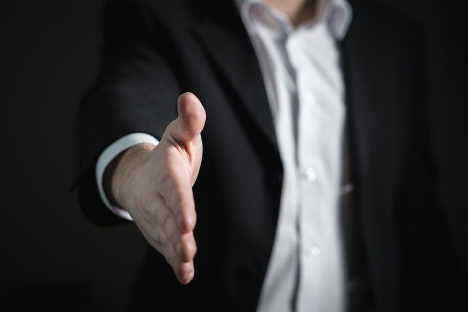 man in a suit going for a handshake