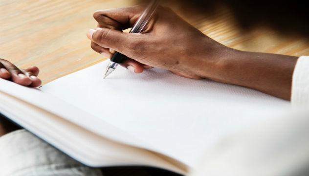 person writing in a notebook