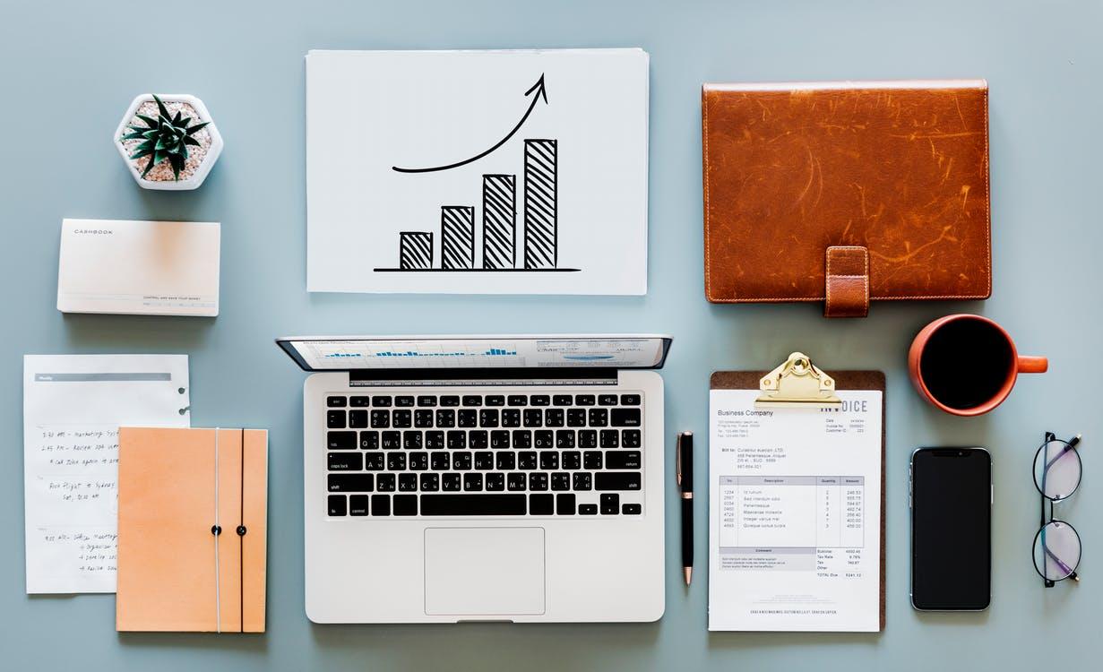 Laptop and Various Office Accessories on a Blue Table