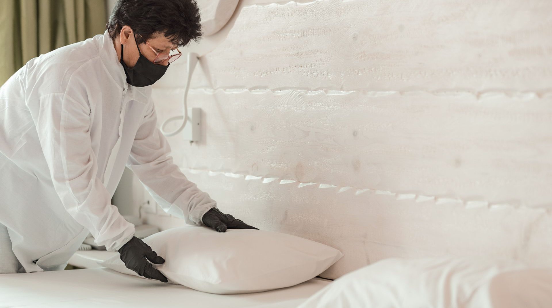 Employee cleaning the room wearing mask and gloves