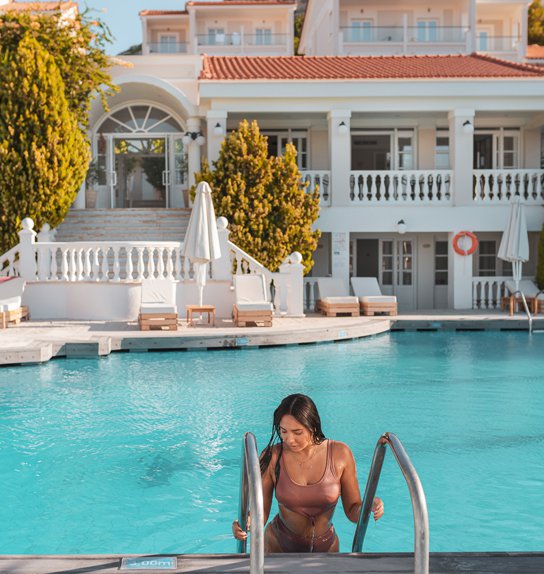 Woman getting out of the pool with our hotel in the background