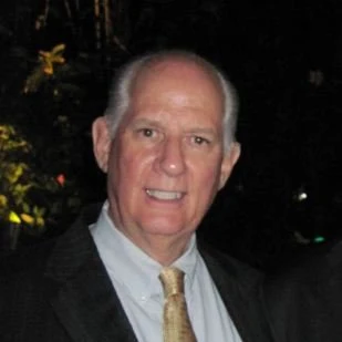 Bruce Weber, smiling, in a jacket and tie