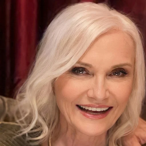 Sandi Jean Weber, smiling, with her silver hair down
