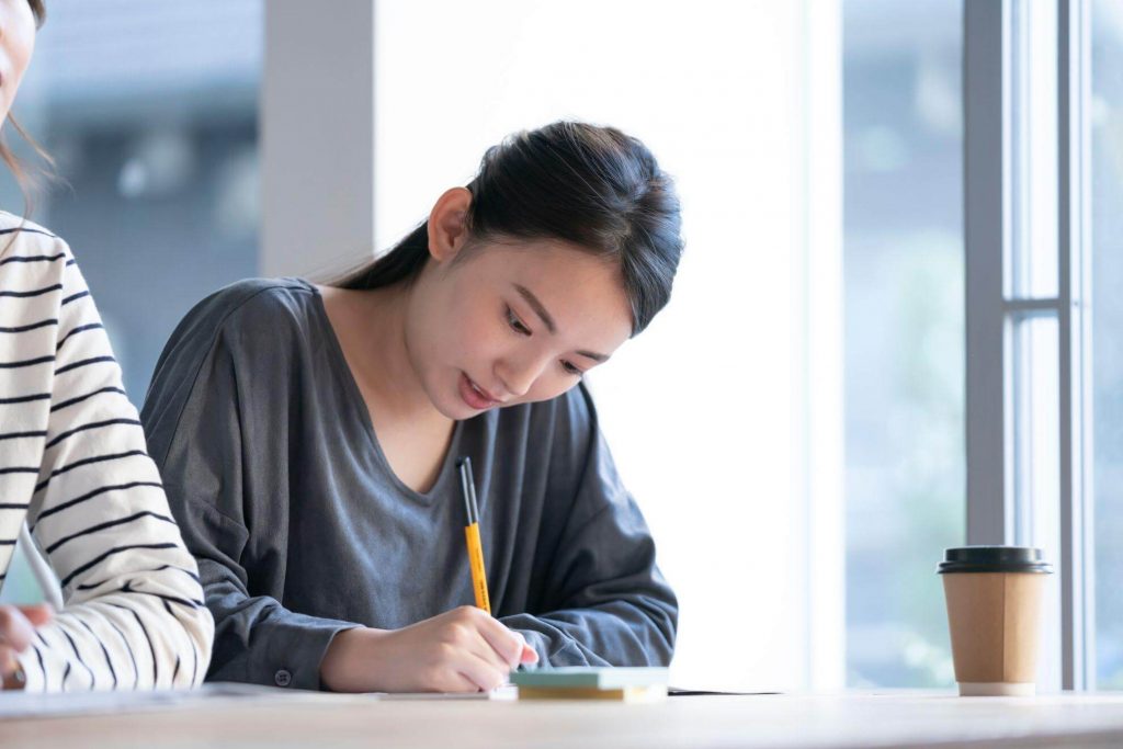 手元のノートに書き込んでいる女性