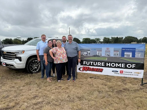 Wagner team in front of the Future Home Of sign