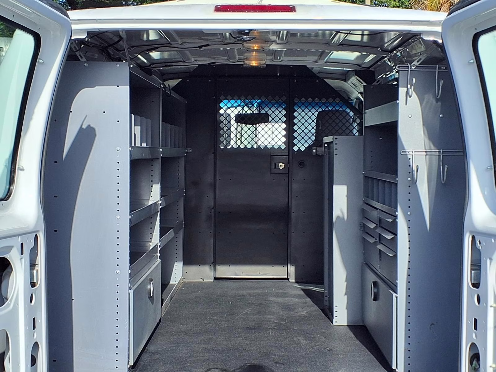 Interior of a white cargo van with storage shelving.