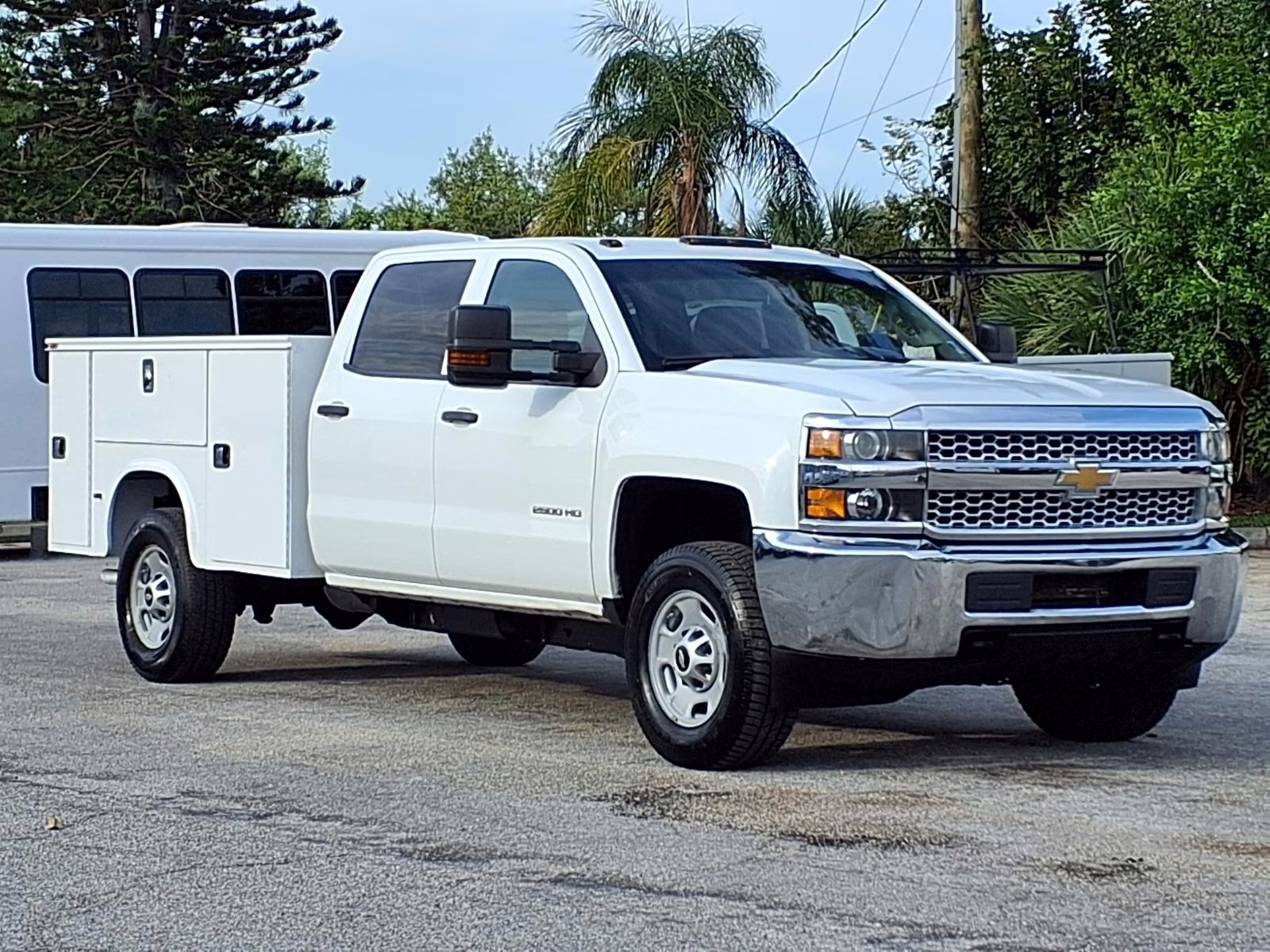 White Chevrolet Silverado 2500HD work truck with utility body.