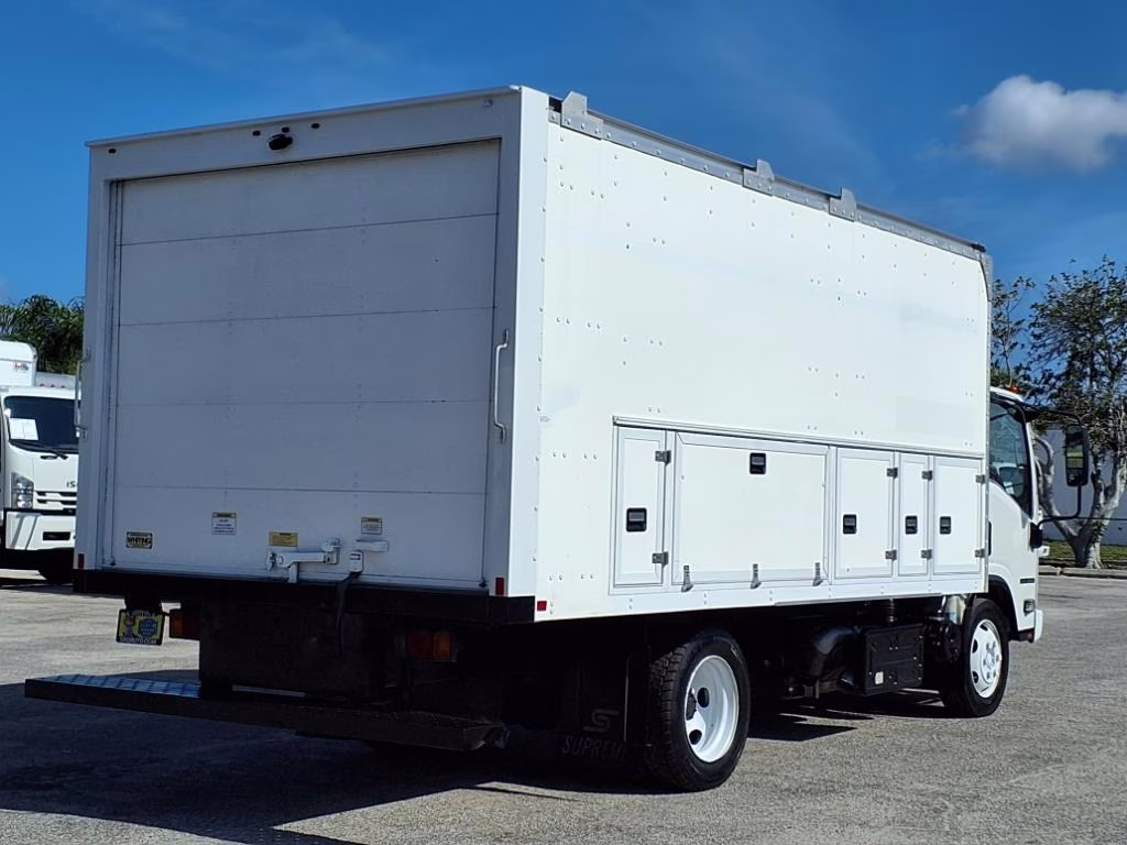 White box truck with roll-up door and side storage compartments.