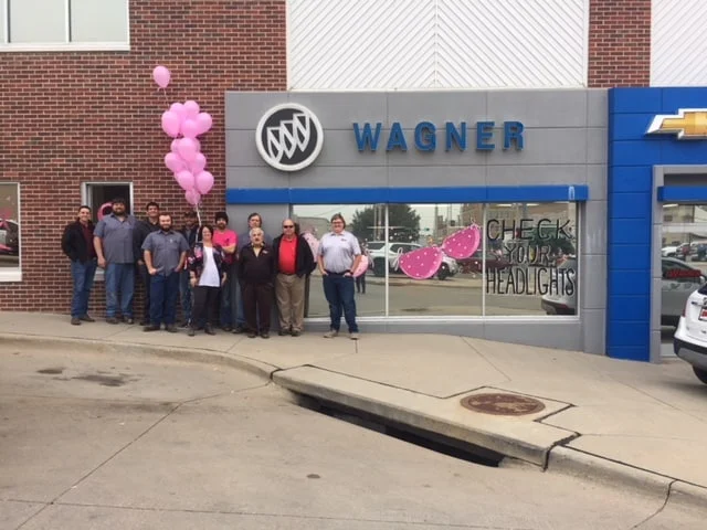 Wagner Chevrolet dealership decorated with pink balloons and breast cancer awareness signage