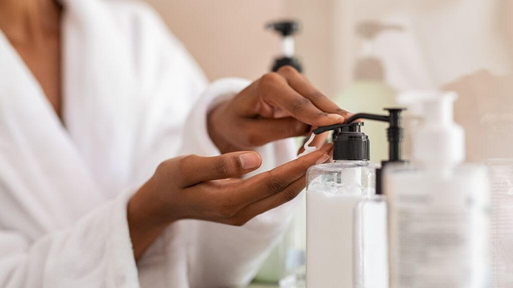 A woman applying moisturizer.