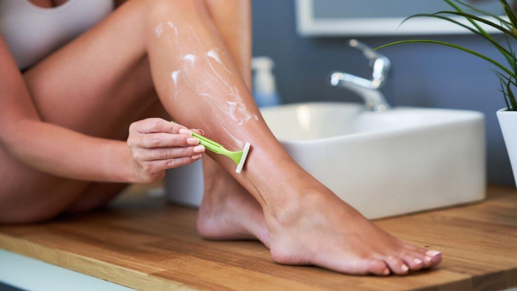 A woman shaving her leg.