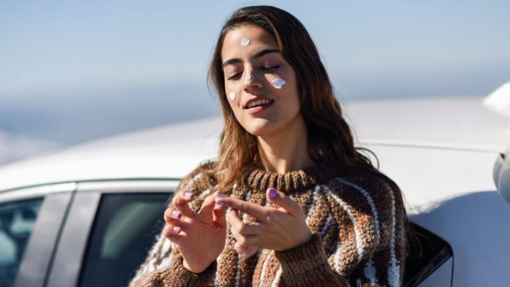 A woman applying sunscreen