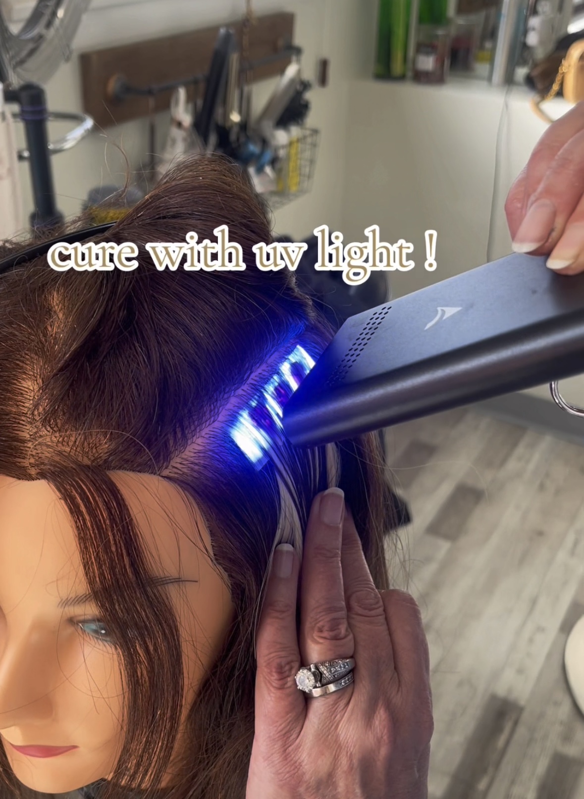 a photo of a hairstylist applying UV Light Hair Extensions