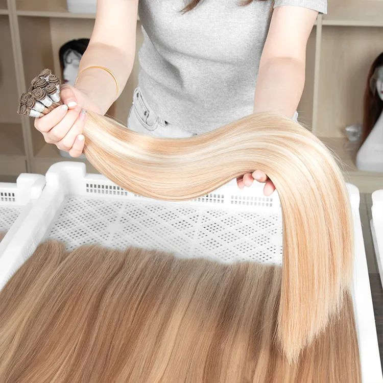 a person holding remy hand tied hair extensions