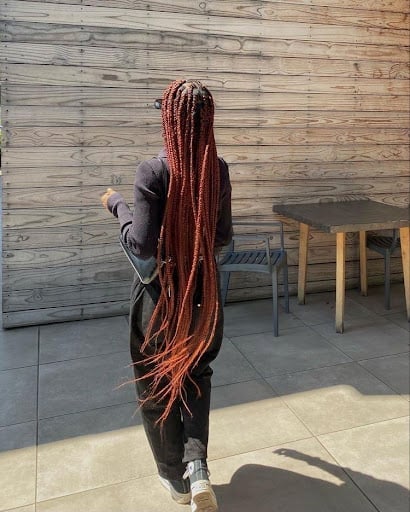 A black woman wearing sincerely4u's Long Waist-Length Box Braids