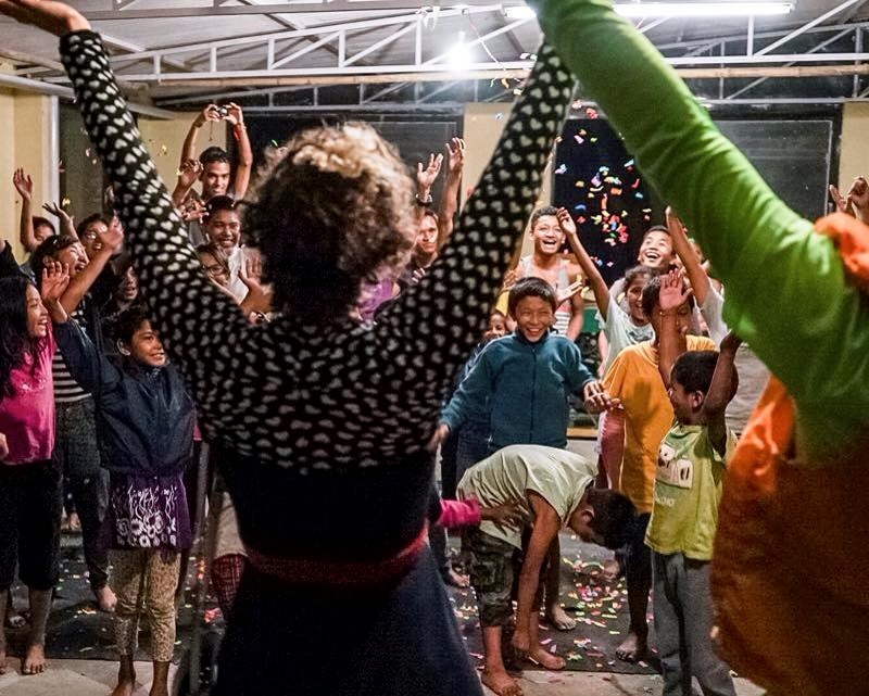 Children throwing confettie with clowns as clowns take a bow