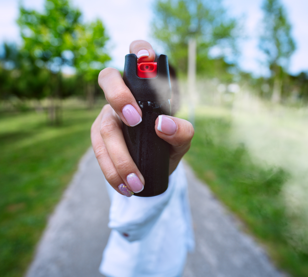 Young woman holding pepper spray close up