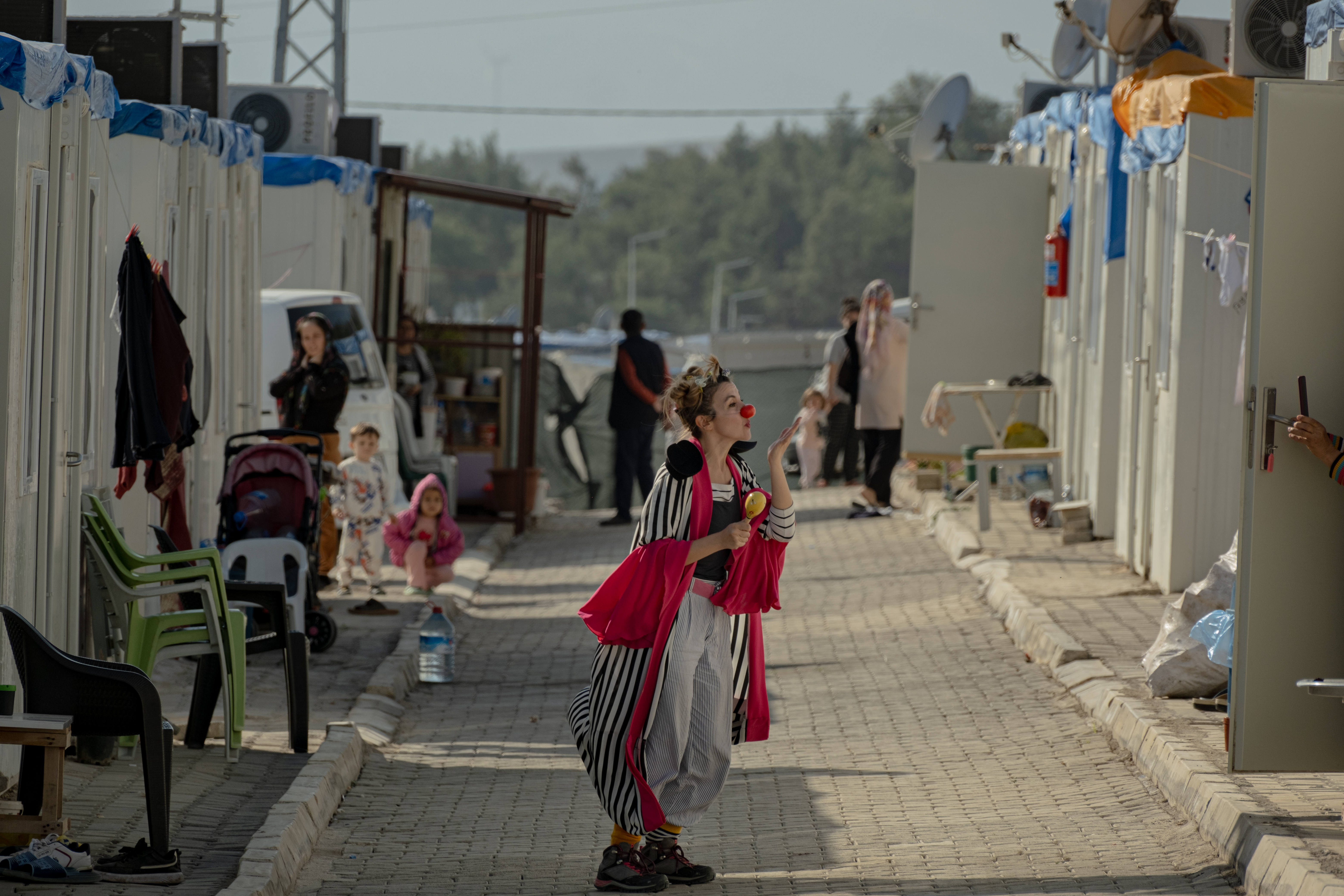 Clown blowing a kiss in temporary container camp
