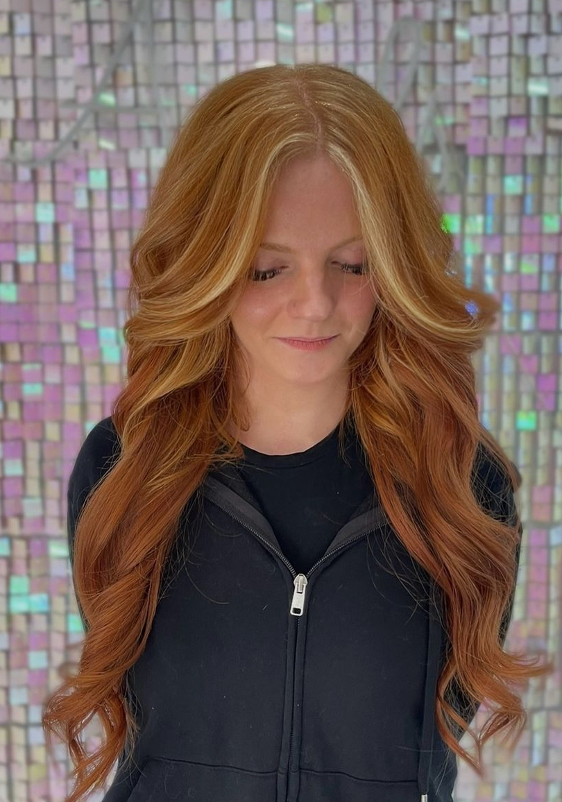 a woman with a partial balayage in copper red