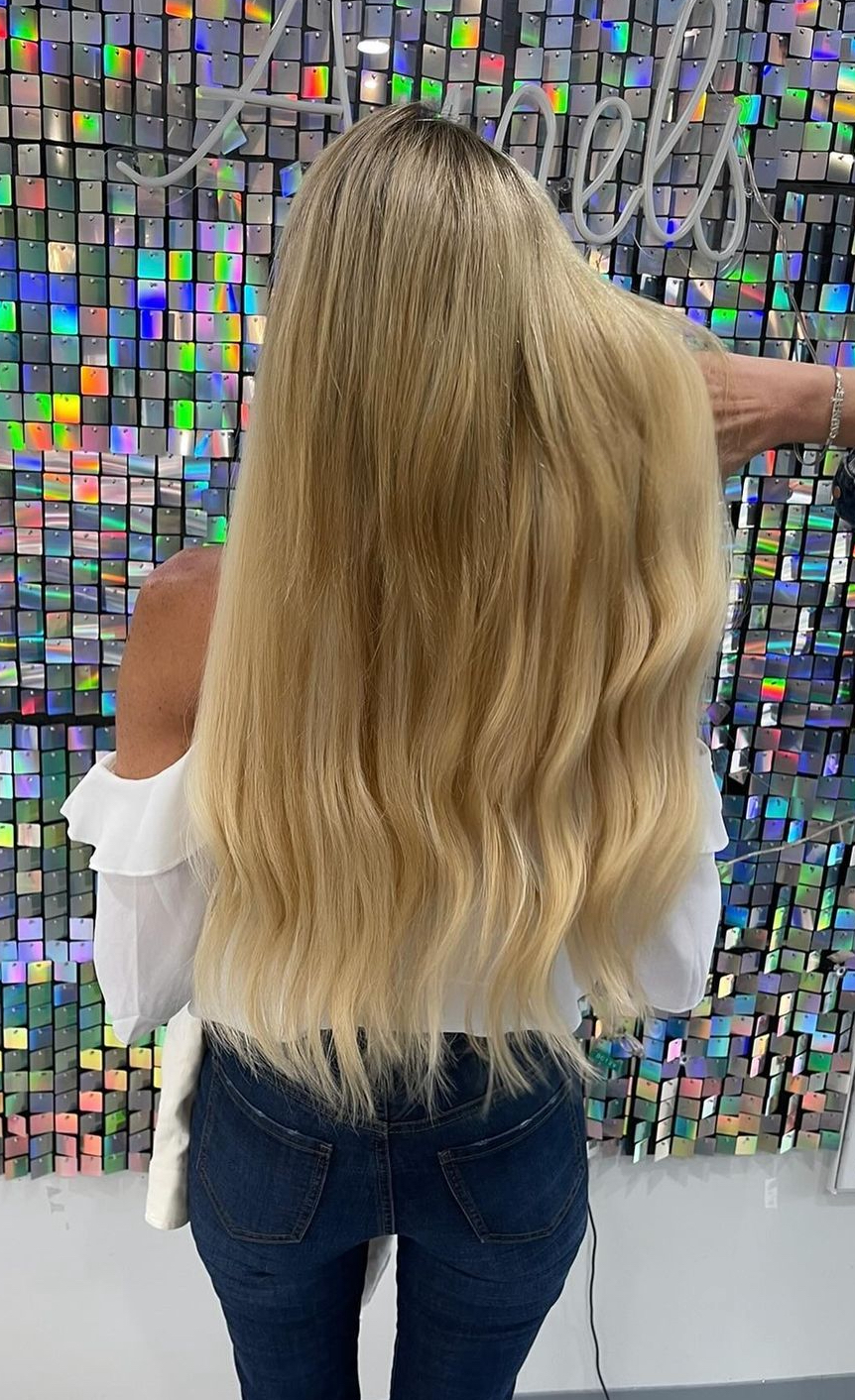 a woman wearing several rows of IBE hair extensions that are well hidden in her hair.
