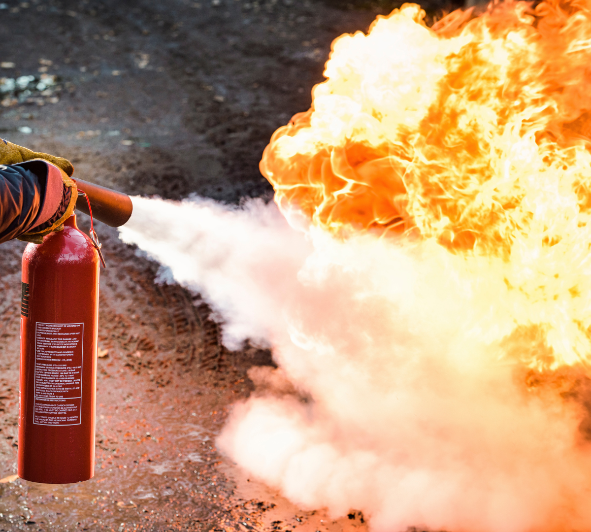 Man using carbon dioxide fire extinguisher to fight a fire