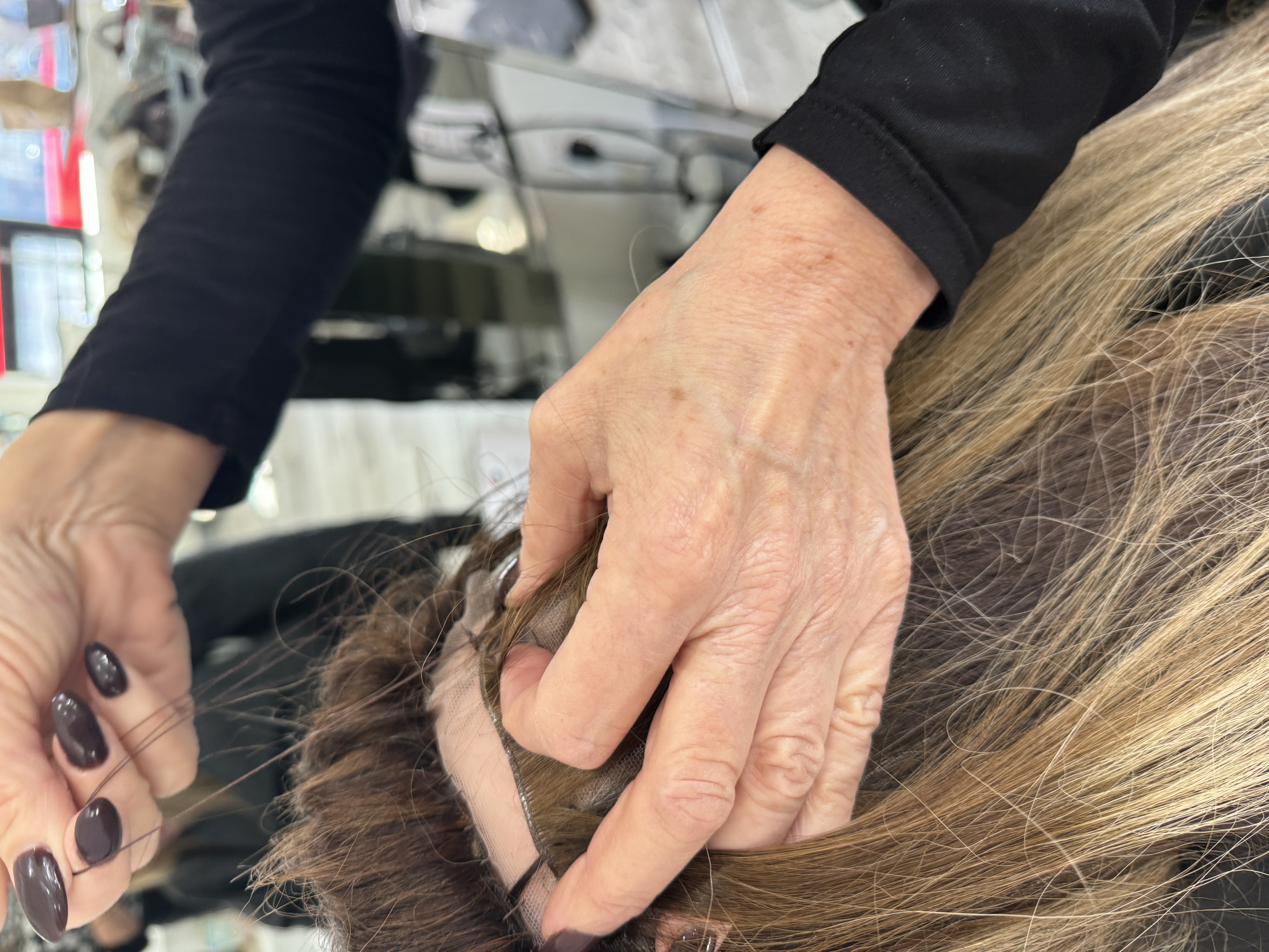 Noelle Salon Stylist customizing a wig on a hair loss client