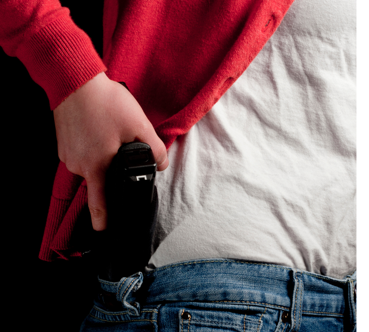 woman drawing firearm from inside waistband holster