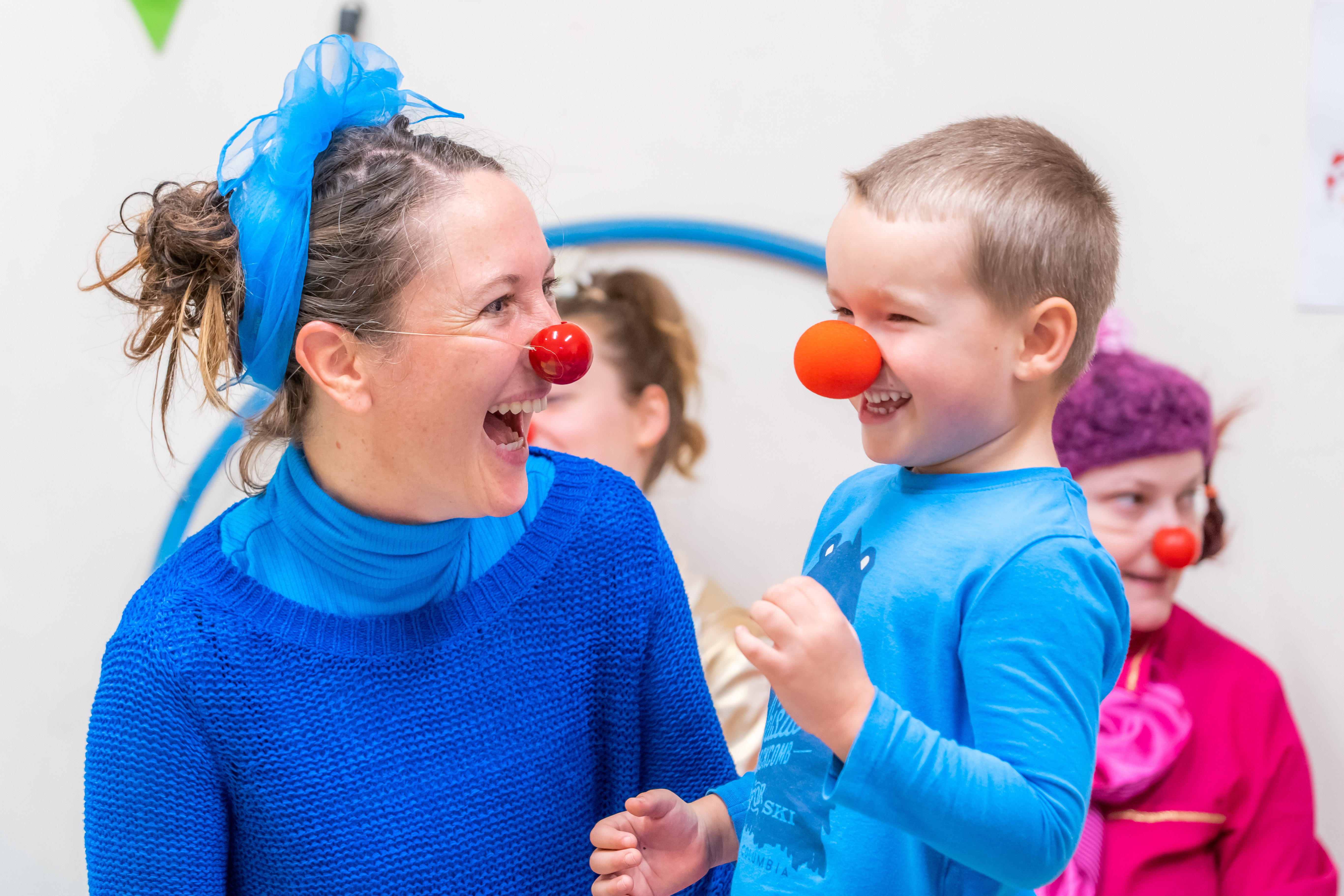 Female clown and child with red nose on laughin