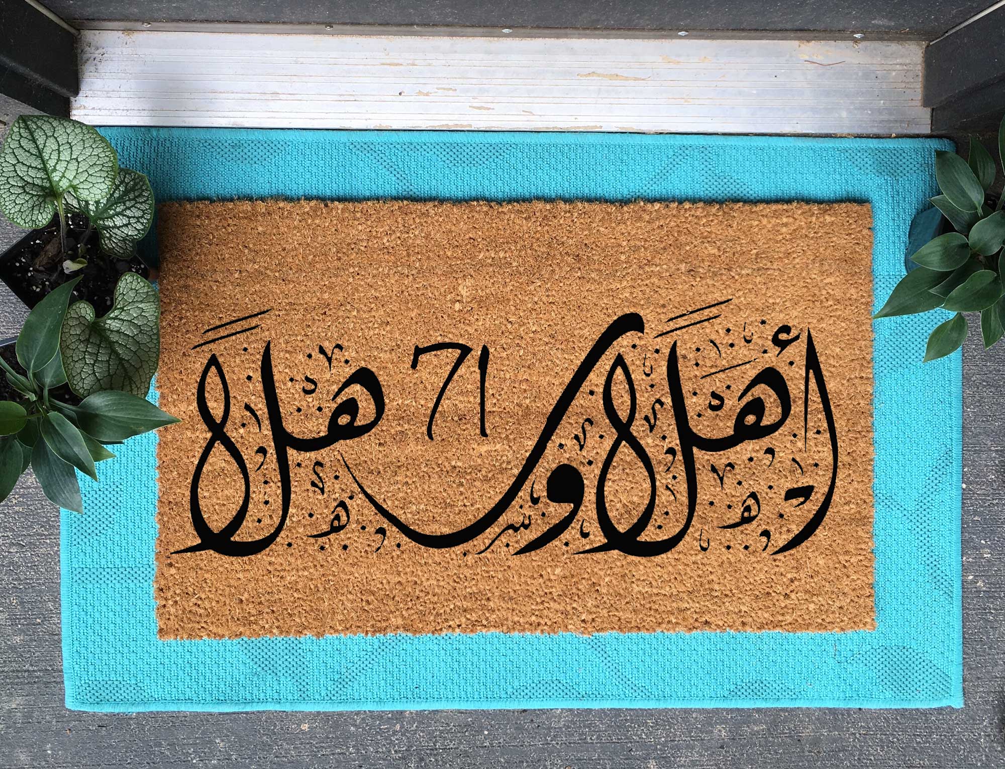 custom coir doormat in arabic on a blue layering rug with houseplants