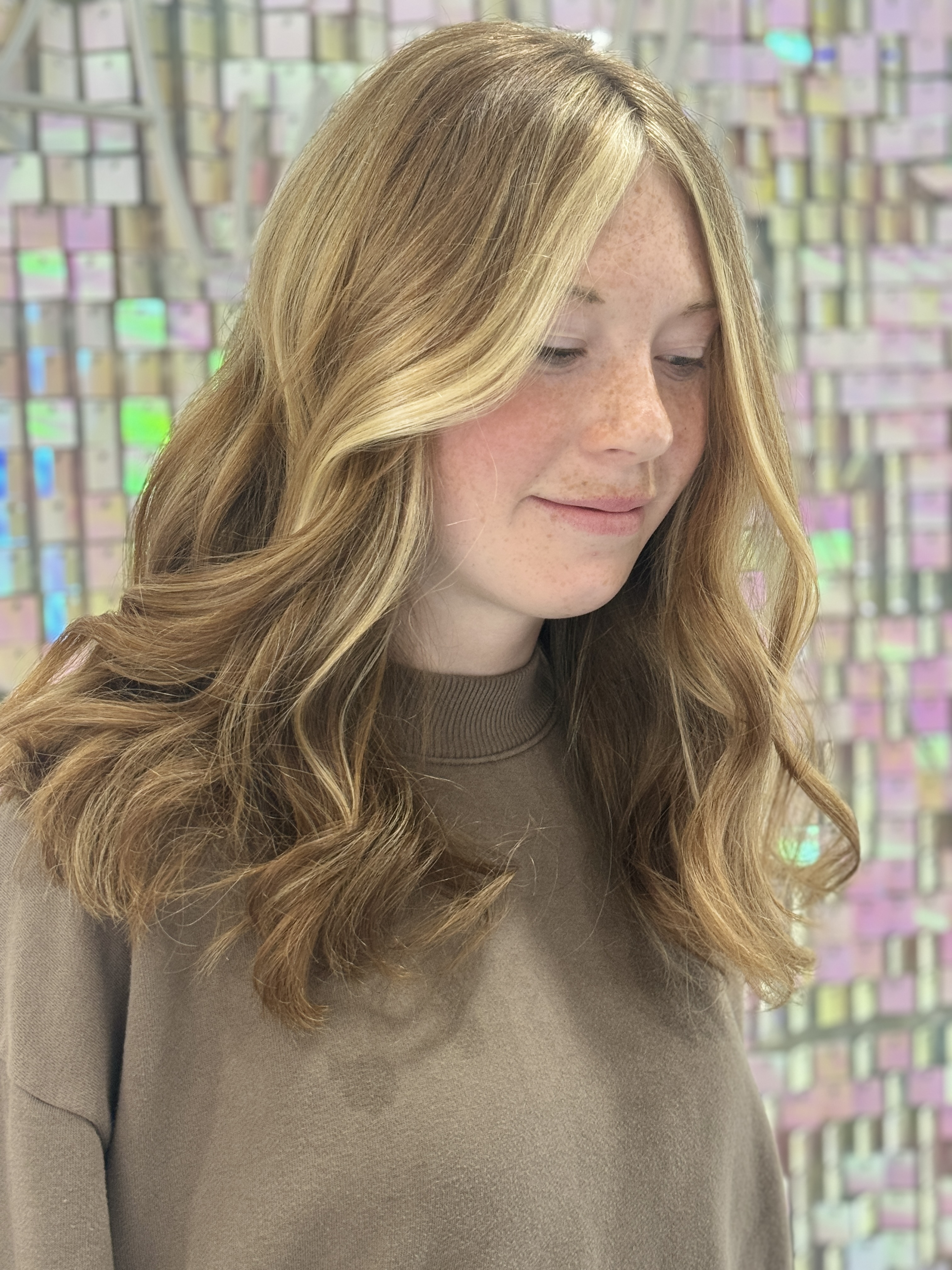 a college student wearing hair extensions in copper blonde color