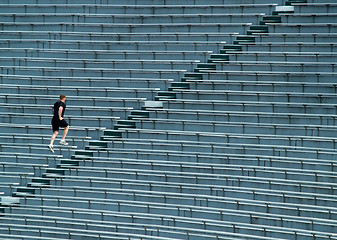 Image showing man running bleachers