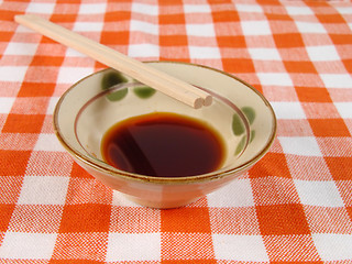 Image showing Soy sauce and chopsticks on a home table