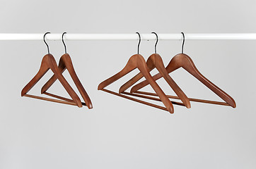 Image showing Wooden hangers on a rod