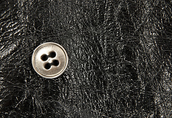 Image showing Metal button on black leather background