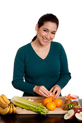 Image showing Woman in kitchen peeling orange