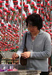 Image showing Woman lighting incense