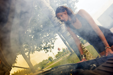 Image showing Woman looking at blown engine