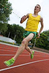 Image showing Running athlete in mid-air