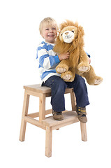 Image showing Boy with toy lion on a stool