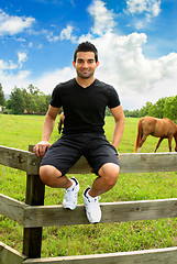 Image showing Man sitting on fence countryside