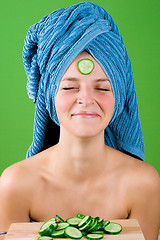 Image showing smiling woman in blue towel and mask from cucumber
