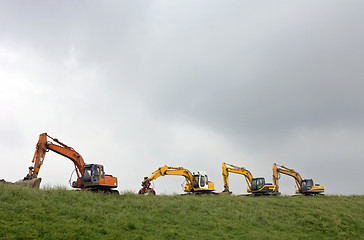 Image showing Four diggers on a dyke