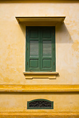 Image showing green window shutters on yellow wall with great shadows 