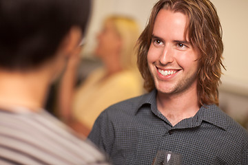 Image showing Smiling Young Man with Glass of Wine Socializing