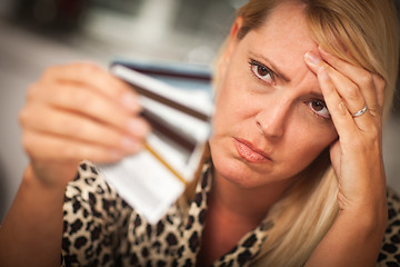 Image showing Upset Woman Glaring At Her Many Credit Cards