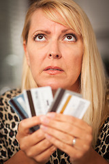 Image showing Upset Woman Glaring At Her Many Credit Cards