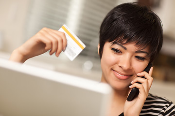 Image showing Multiethnic Woman Holding Phone and Credit Card Using Laptop