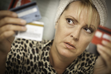 Image showing Upset Woman Glaring At Her Many Credit Cards.